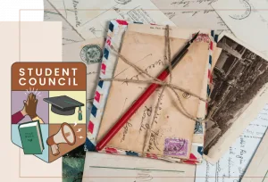 a pen on a stack of letters with the student council badge