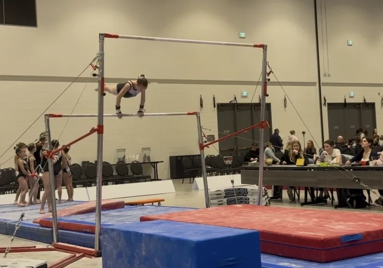 Emily performing gymnastics on bars