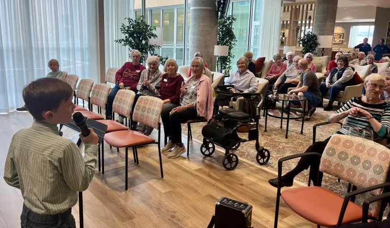 A crowd of elderly residents watching the Lyrics Lads