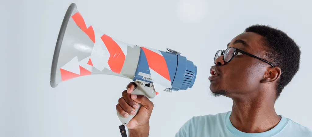 man in a blue shirt holding a megaphone