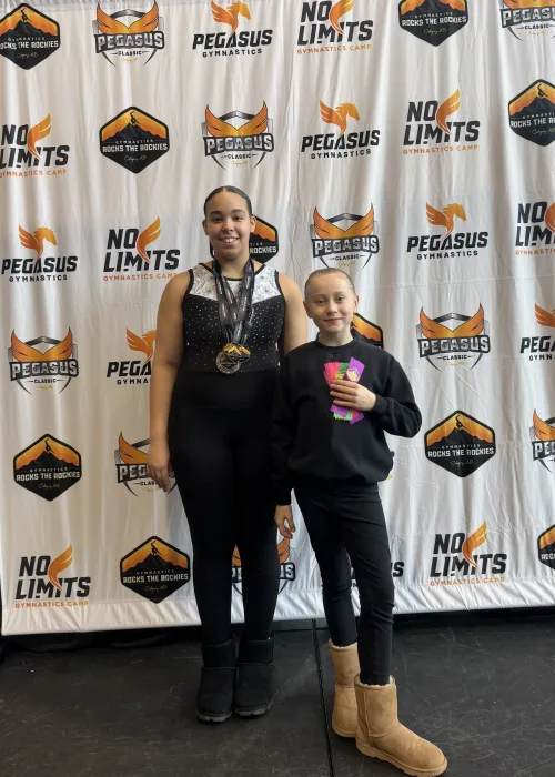 Emily standing with Hannah in front of a backdrop