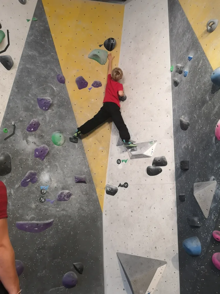 Nathaniel reaching for the top of the climbing wall